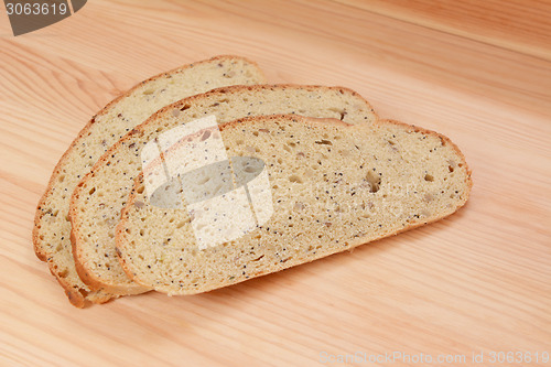 Image of Three slices of bread on a wooden table