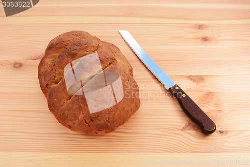 Image of Freshly baked loaf with a bread knife 