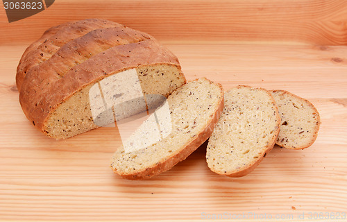 Image of Three slices of fresh bread next to the loaf