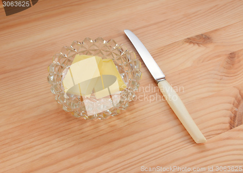 Image of Butter in a glass dish with a small knife for spreading