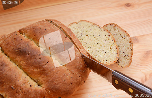 Image of Cutting slices of bread on a wooden table