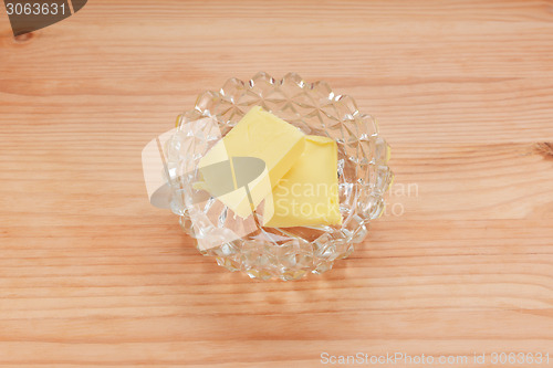 Image of Two pats of butter in a glass dish