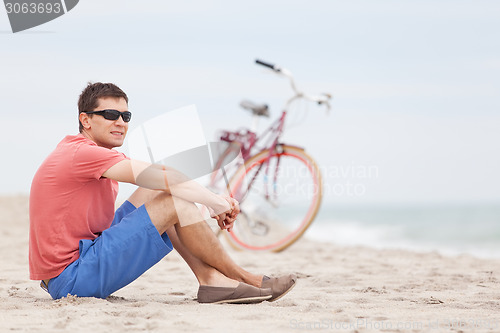 Image of man biking at the beach