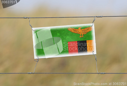 Image of Border fence - Old plastic sign with a flag