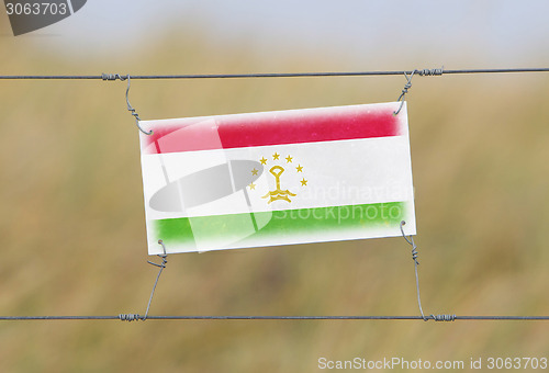 Image of Border fence - Old plastic sign with a flag