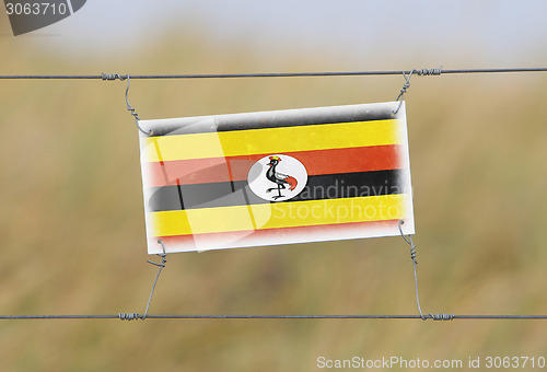 Image of Border fence - Old plastic sign with a flag