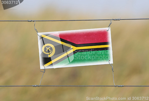 Image of Border fence - Old plastic sign with a flag