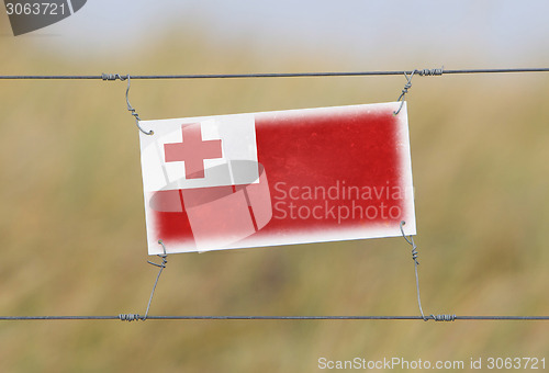 Image of Border fence - Old plastic sign with a flag