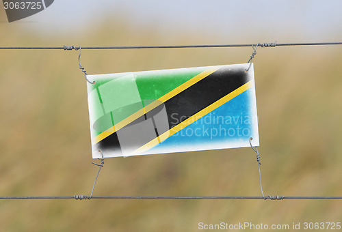 Image of Border fence - Old plastic sign with a flag