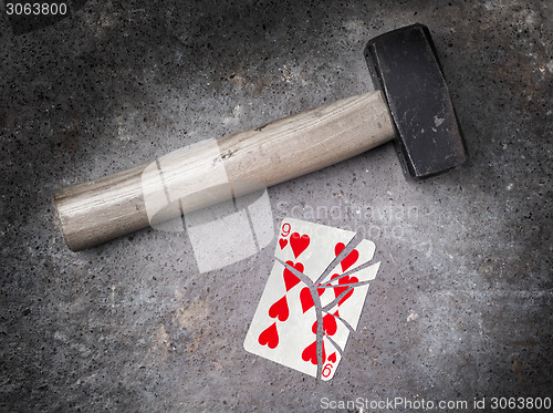 Image of Hammer with a broken card, nine of hearts