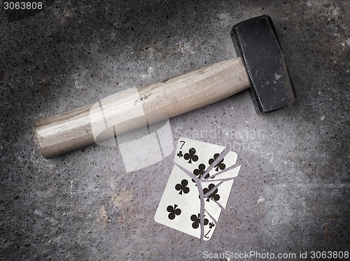 Image of Hammer with a broken card, seven of clubs