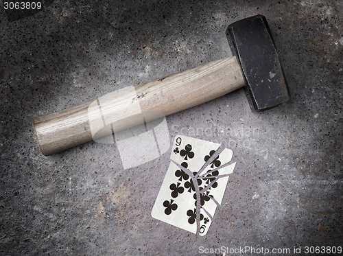 Image of Hammer with a broken card, nine of clubs