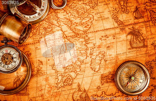 Image of Vintage magnifying glass lies on an ancient world map