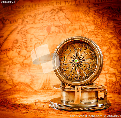 Image of Vintage compass lies on an ancient world map.