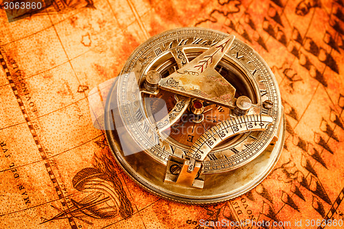 Image of Vintage compass lies on an ancient world map.