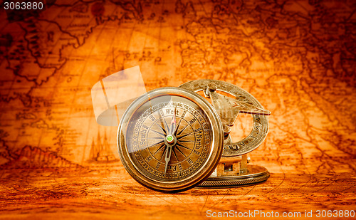 Image of Vintage compass lies on an ancient world map.