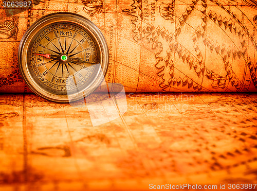 Image of Vintage compass lies on an ancient world map.