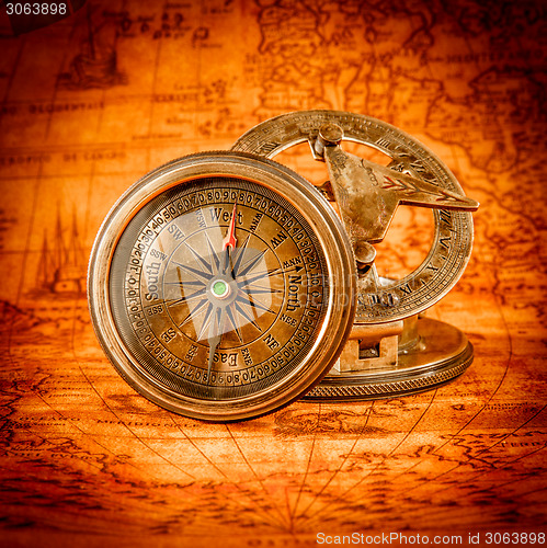 Image of Vintage compass lies on an ancient world map.