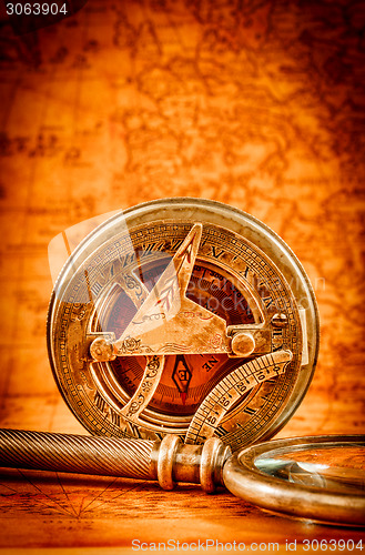 Image of Vintage compass lies on an ancient world map.