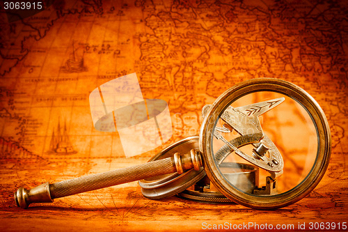 Image of Vintage magnifying glass lies on an ancient world map