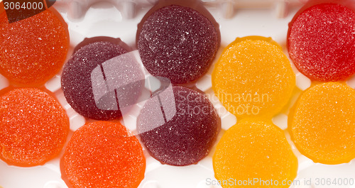 Image of Round jelly sprinkled with sugar in a plastic box.
