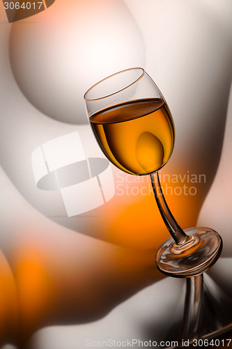 Image of glass of cognac in a distorted reflection