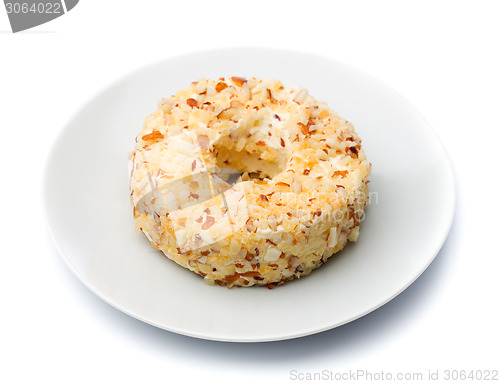 Image of Round sweet dessert cheese with nuts and pineapple on a white pl