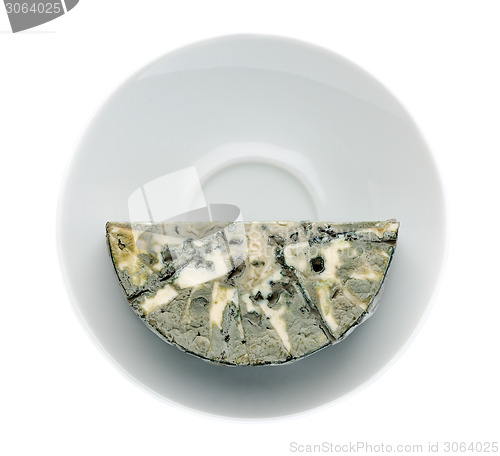 Image of Cheese with black mold on the plate. View from above.