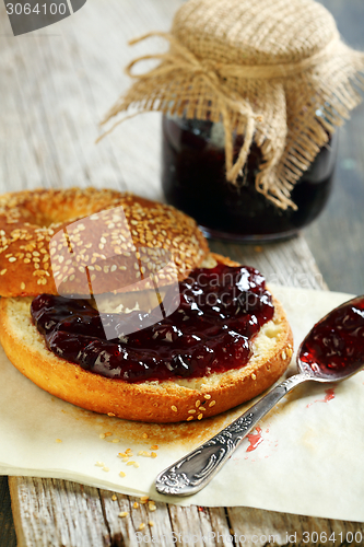 Image of Homemade bagel with jam and tea spoon.