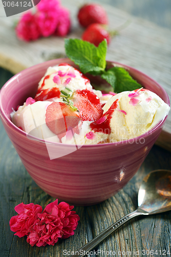 Image of Berries and ice cream in a pink cup.