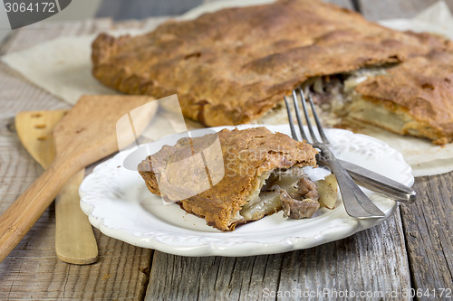 Image of Pie with meat and potatoes on the plate.