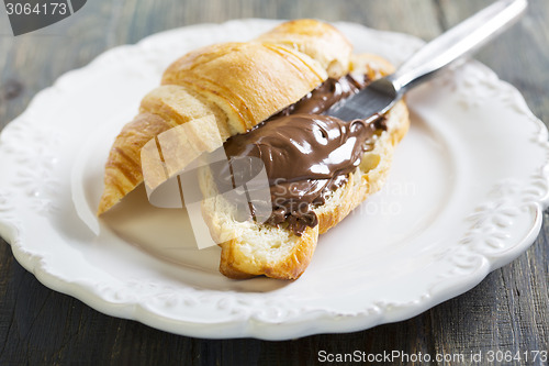 Image of Plate with croissant and chocolate. 