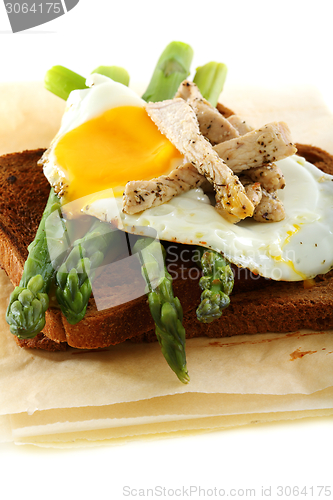 Image of Asparagus, egg and turkey on rye bread.