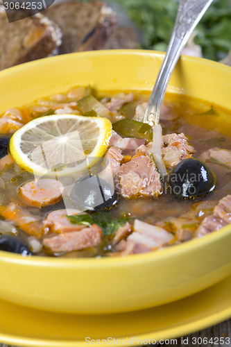 Image of Thick meat soup and a spoon in a plate.