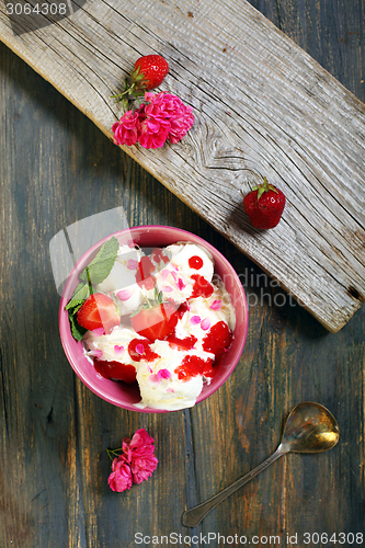 Image of Ice cream with strawberries and rose petals.