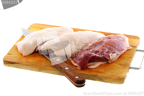Image of Duck breast with a kitchen knife.