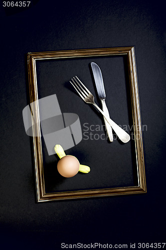 Image of Egg in a stand, fork and knife.