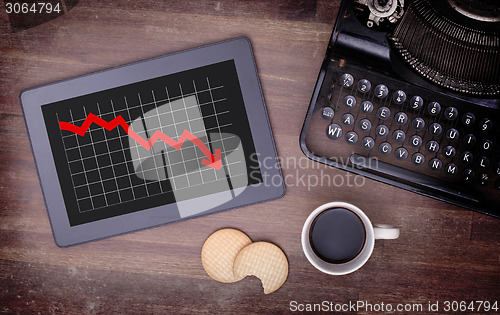 Image of Tablet touch computer gadget on wooden table, graph negative