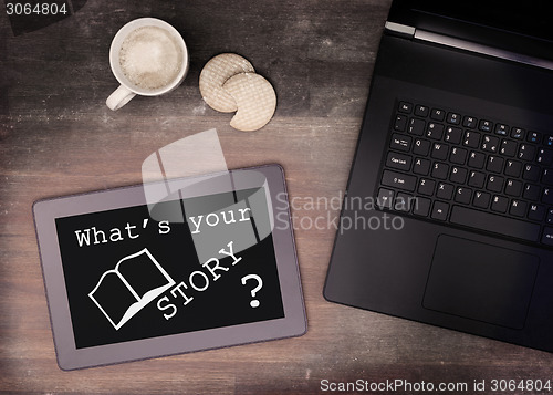 Image of Tablet touch computer gadget on wooden table, what's your story