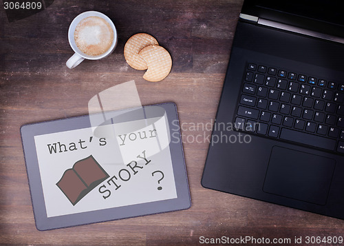 Image of Tablet touch computer gadget on wooden table, what's your story