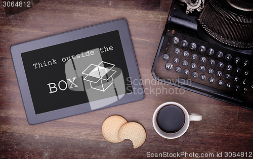 Image of Tablet touch computer gadget on wooden table, think outside the 