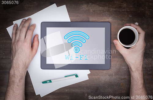 Image of Tablet with Wi-Fi connection on a wooden desk