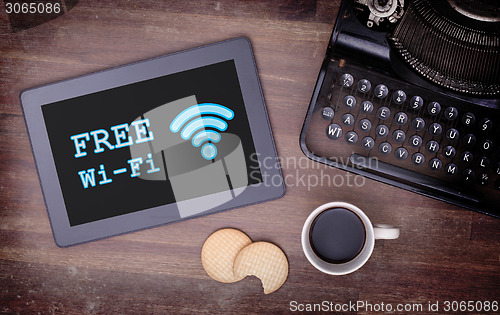 Image of Tablet with Wi-Fi connection on a wooden desk