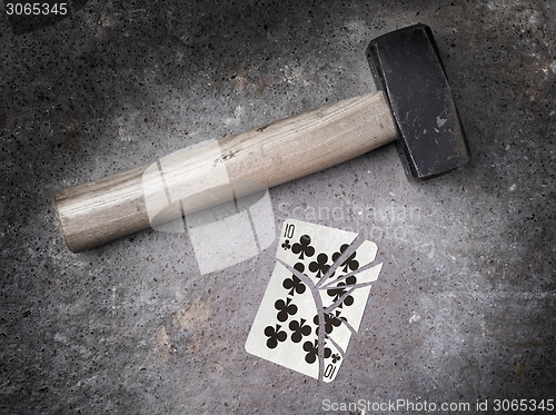 Image of Hammer with a broken card, ten of clubs