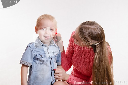 Image of Mom playfully took his son by the ear