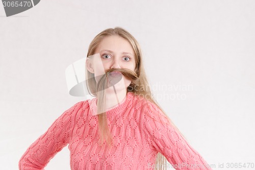 Image of Cheerful girl mustache made a lock of hair