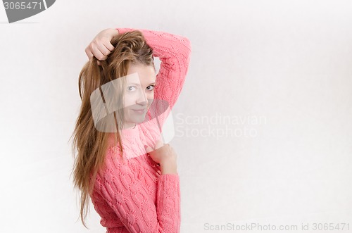 Image of Cheerful girl holding a hand through his hair