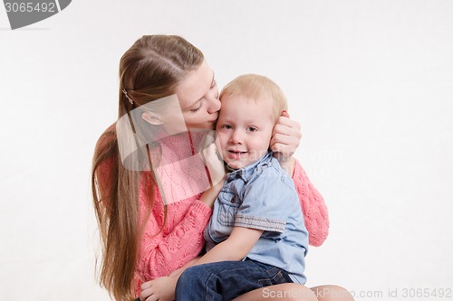 Image of Young mother kissing her son three years