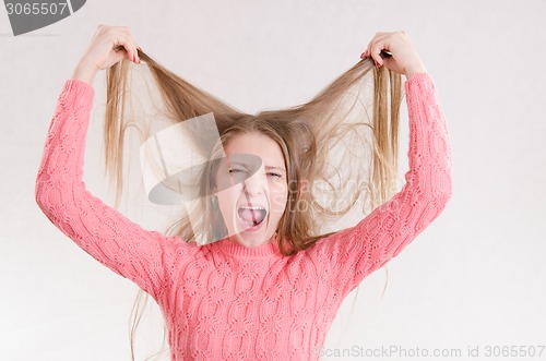 Image of Girl screams hair raising his hands above him