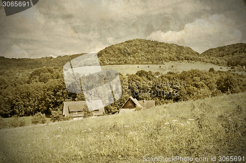 Image of country idyll with old farmhouse and hill